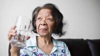 Senior woman holding glass of water