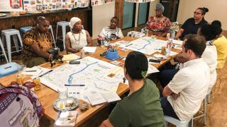 People sitting around a table, mostly women of color