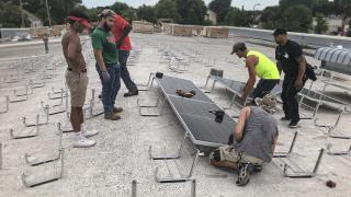 People installing solar panels on a rooftop