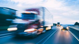 Cars and trucks driving on a highway.