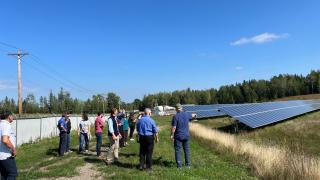 Group of people looking at solar panels in an open space