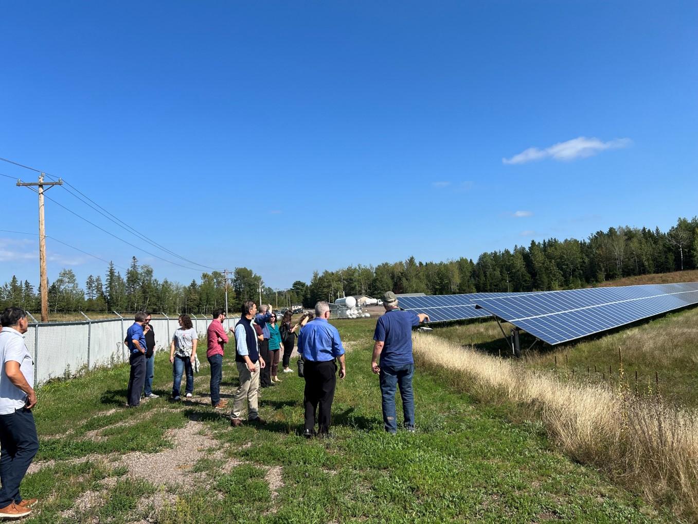Group of people looking at solar panels in an open space