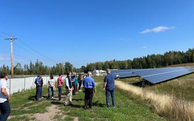 Group of people looking at solar panels in an open space